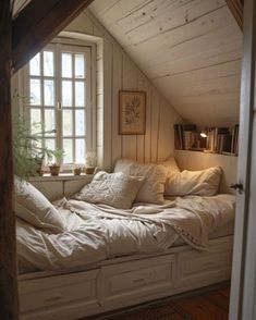 a window seat in the corner of a room with pillows and blankets on top of it