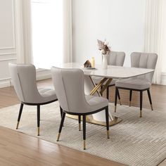 a dining room table with chairs and a rug in front of the table is an area rug that has been placed on top of it