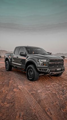 a truck is parked in the middle of a dirt field