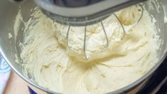 a mixer filled with white batter sitting on top of a counter