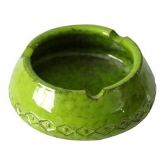 a green ceramic bowl is shown on a white background