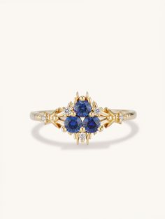 a yellow gold ring with blue sapphires and diamonds