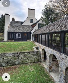 an old stone house with a green lawn