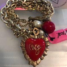 Vintage Gold Colored Chain Link Bracelet With Red Heart Pillow Charm With Betsey Johnson’s Signature Initials On One Side And Be My Valentine On The Other Side Luxury Red Jewelry With Heart Charm, Elegant Red Charm Bracelet With Lobster Clasp, Red Heart-shaped Metal Bracelets, Red Heart-shaped Metal Bracelet, Elegant Red Charm Bracelet With Heart Charm, Red Heart-shaped Elegant Charm Bracelet, Vintage Red Jewelry With Heart Charm, Elegant Red Bracelets With Heart Charm, Elegant Red Charm Bracelet