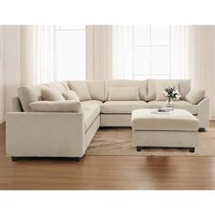 a living room scene with focus on the sectional sofa and footstool, along with a coffee table