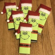 six green christmas crackers with santa hats on them