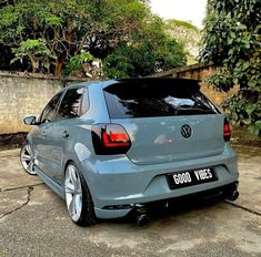 the rear end of a blue car parked in a driveway