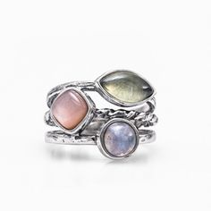 A shining stack of high-quality 925 sterling silver in tapering multi-textured bands sets with three unique multi colored gemstones in this celestial design. A round 1.1 ct. cabochon of rainbow moonstone radiates next to a 1 ct. cushion-cut pink moonstone, which glimmers next to a 1.3 ct. marquise-cut cabochon of prehnite. DETAILS: * Metal: Sterling silver * Stones: ‣ Rainbow moonstone round-cab 1.1 ct. ‣ Cushion pink moonstone 1 ct. ‣ Prehnite marquise-cab 1.3 ct. * Available sizes: 5-10 * Shap Celestial Design, Pink Moonstone, Colored Gemstones, Rainbow Moonstone Ring, Purple Band, Gem Ring, Ring Boho, Elegant Ring, Multi Stone Ring