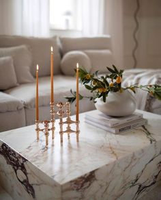 a marble coffee table with candles on it