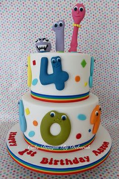 a three tiered birthday cake with monsters on it