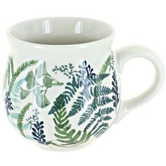 a white coffee cup with green leaves on it