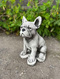 a small statue of a dog sitting on the ground