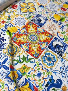 a table covered in colorful tiles and designs on it's surface, with a piece of paper sticking out of the middle