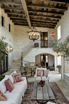 a living room filled with furniture and a fire place next to a staircase leading up to a second story