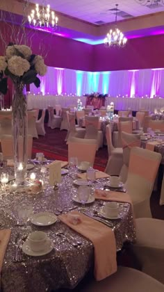 the tables are set with silver and pink linens