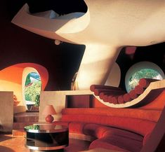 a living room with orange couches and round windows