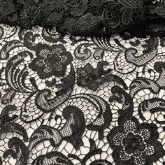 black and white lace fabric with floral design on it, close up view from the bottom