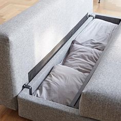 a couch that has some sort of storage in the middle of it, and is open to show what's inside