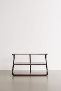 a wooden table sitting on top of a hard wood floor next to a white wall