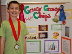 a young boy is standing in front of a poster with his medal around his neck