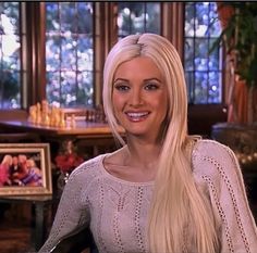 a woman with long blonde hair sitting in a chair