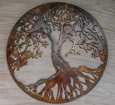 a metal tree with lots of leaves on it sitting on top of a wooden table