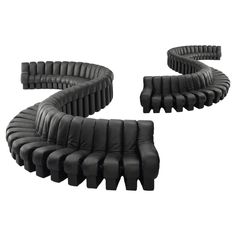 the curved black leather couches are arranged in a spiral pattern and have been placed together