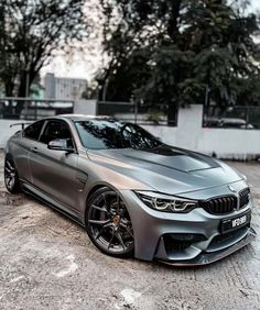 a silver car parked in front of some trees