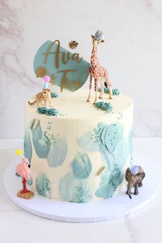 a cake decorated with giraffes and other animals on top of a table