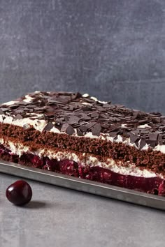 a piece of cake with chocolate and cherries on the side next to a cherry