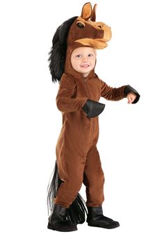 a little boy in a horse costume standing on one leg and smiling at the camera