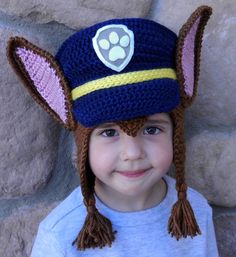 a young boy wearing a crocheted hat with ears and paw prints on it