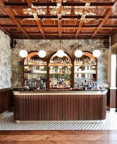 the inside of a restaurant with wooden ceilings and tiled flooring, along with bar stools