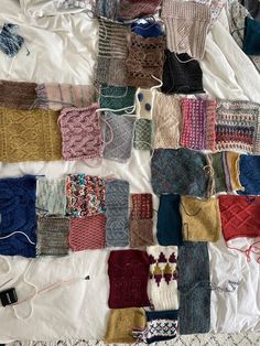 there are many knitted items laid out on the bed