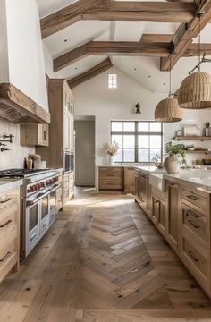 a large kitchen with wooden floors and white walls, along with an island in the middle