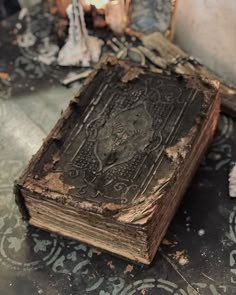 an old book sitting on top of a floor next to a candle and some other items