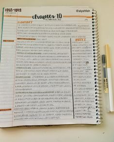 an open planner with writing on it next to a pen