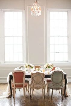 a dining room table with four chairs and a chandelier