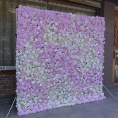 there is a large flower wall on the sidewalk