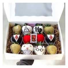 a box filled with chocolate covered strawberries and topped with harry potter themed candies