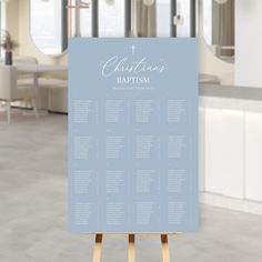 a blue and white wedding seating chart on a wooden easel in a large room