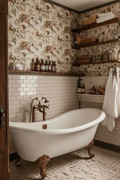 an old fashioned bathtub in a bathroom with floral wallpaper and wooden shelving