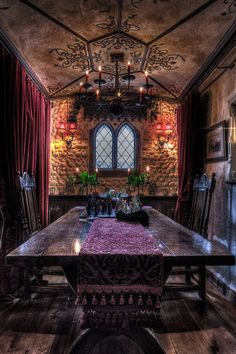 a dining room with a table, chairs and chandelier in the middle of it