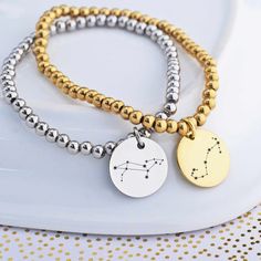 Show your stellar style with this Custom Constellation Stretch Bracelet! It's a unique "celestial" accessory, with a charm for each of the 12 astrological signs. Choose either silver or gold for a dazzling finish - and keep your star sign close to your heart. #outofthisworld! DETAILS: SIZES: S/M (5 to 6.5 inches) or M/L (6 to 7.5 inches) COLORS: stainless steel or yellow gold plated steel STYLE: beads on a stretchable cord, fits over hand CHARM: 5/8 inch (15mm) round Celestial Metal Bracelet For Gift, Celestial Adjustable Charm Bracelet Gift, Gold Spiritual Bracelets With Zodiac Sign, Gold Zodiac Sign Bracelet, Celestial Silver Metal Bracelets, Celestial Style Silver Metal Bracelets, Symbolic Zodiac Sign Bracelet Jewelry, Silver Zodiac Sign Bracelet, Silver Zodiac Sign Symbolic Bracelets