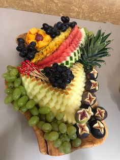 a fruit platter with grapes, melon, pineapple and other fruits