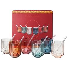 a set of six glass cups and spoons in front of a red box