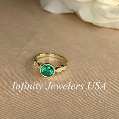 "The ring pictured is lab created emerald with moissanite accents #7056 -Approximate total carat weight: 1.26ctw diamond equivalent -Center Stone Size: 7mm - approx. 1.20ct diamond equivalent -Center Stone Shape: round -Gem Type: lab created emerald -Stone Clarity: VS2 -Stone Color: green -Moh's Scale: 8.5 hardness -Accent Stones: 2 rounds - approx. 0.06ctw. diamond equivalent -Gem Type: moissanite -Stone Clarity: VS2 -Stone Color: FG -Moh's Scale: 9.25 hardness -Metal Type and Purity: 14k white Diamond May Birthstone Ring With Center Stone, Diamond Birthstone Ring With Center Stone For May, Oval Emerald Diamond Ring With Bezel Setting, Fine Jewelry Round Cut Emerald Ring With Accent Stones, Heirloom Emerald Ring With Accent Stones And Round Cut, Heirloom Style Emerald Ring With Accent Stones, Moissanite Birthstone Ring With Center Stone, Heirloom Style Moissanite Emerald Ring With Prong Setting, Heirloom Emerald Moissanite Ring With Prong Setting