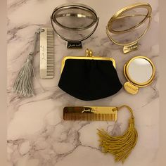 the contents of a women's purse laid out on a marble counter top, including a comb, magnifying glass and other accessories