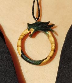 This is a 100% handmade Resin & Stabilized Olive Wooden necklace. I'm proud to have this handmade necklace in my shop. This Ouroboros Dragon pendant will make a perfect unique gift for Christmas, i will send it in a nice gift box. This necklace is made of Resin & Stabilized Wood and completely handcrafted. Every detail is carefully handcarved. Cord is adjustable Ready and packed for shipping, what you see is exactly what you get. Please contact me for custom order. Carved Spiritual Jewelry Gift, Spiritual Carved Jewelry As Gift, Unique Personalized Round Pendant Necklaces, Carved Amulet Jewelry For Gifts, Carved Amulet Jewelry For Gift, Nature-inspired Pendant Necklace With Hand Painted Details, Hand Painted Nature-inspired Pendant Necklace, Nature-inspired Hand Painted Pendant Necklace, Personalized Amulet Jewelry For Collectors