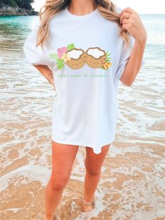 "Enjoy a fun play on words or get ready for a tropical vacation with a touch of humor by wearing this delightful t-shirt adorned with a playful depiction of coconuts and the words \"Lovely Bunch of Coconuts,\" perfect for a gift and those who enjoy a lighthearted design. *Measurement Tips* Please note the sizing chart is based on one side of the T-shirt, not the circumference. This T-Shirt is unisex so please measure your favourite T-shirt for the most accurate fit you would like. If you want a over-sized style, go up about 2 sizes.  All measurements are approximations. They may be within 1\" of the dimensions listed *Product* Product colour may slightly vary due to photo lighting or your monitor settings The double-needle stitching throughout the tee makes it highly durable while the lack Coconut Summer, Vacation Tops, Vegan Gifts, Top Funny, Tropical Fruit, Tropical Vacation, Photo Lighting, Summer Tshirts, Sizing Chart